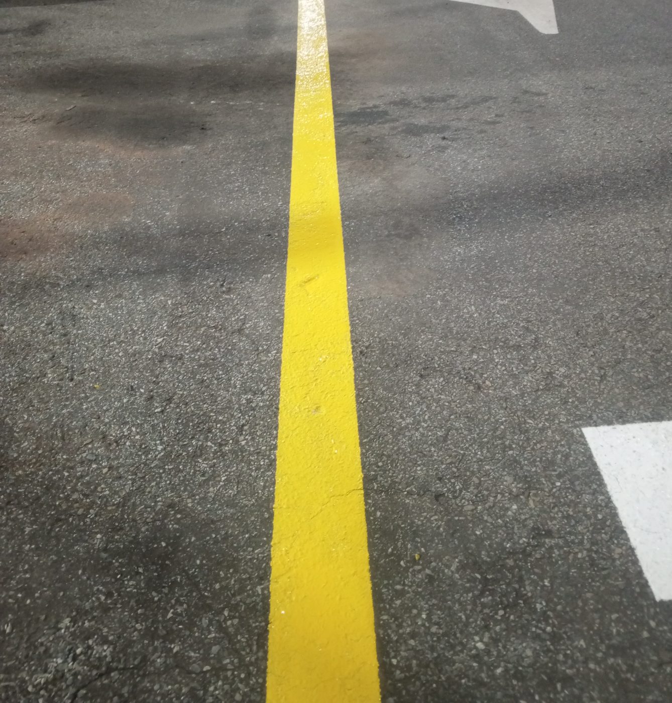 Faixa amarela de divisão de pista e seta de direção
