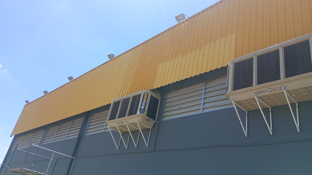 Repintura de fachada metálica de supermercado — à direita, já pintada