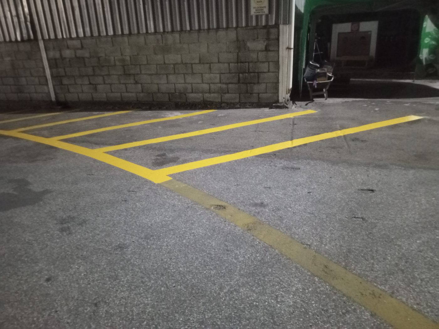 Demarcação de vagas em amarelo junto ao galpão